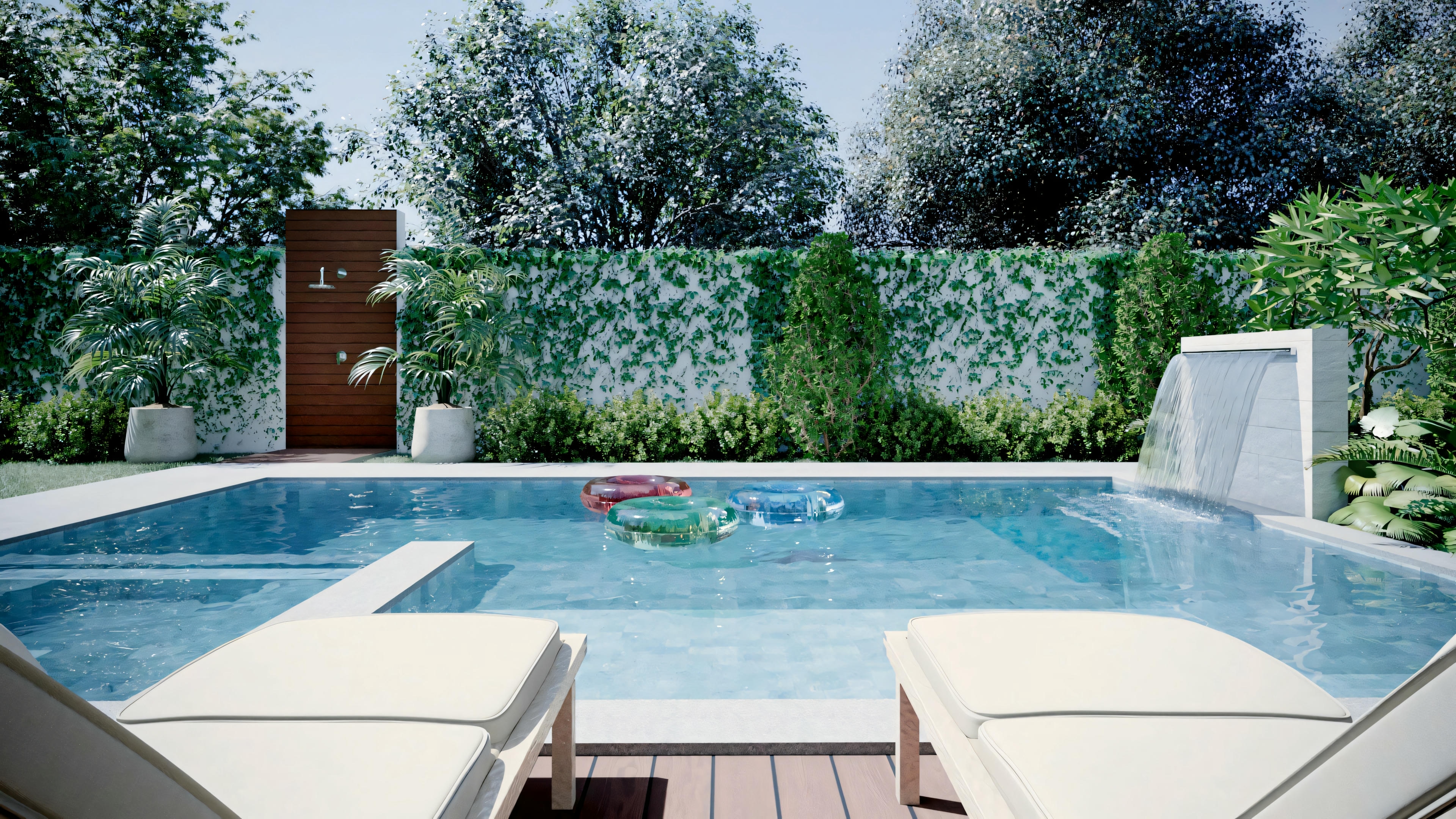 An outdoor area with a pool, surrounded by lush greenery and two lounge chairs.
