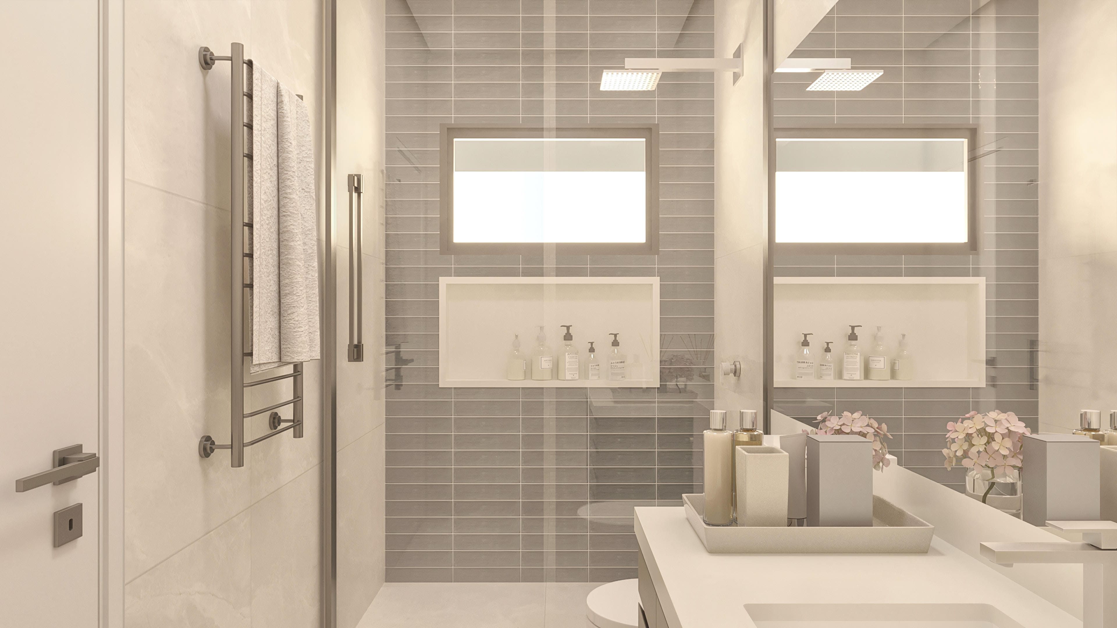 Encimera de baño con lavabos esculpidos, amplio espejo y hornacinas con artículos de aseo. Revestimiento de gresite y detalles en mármol.