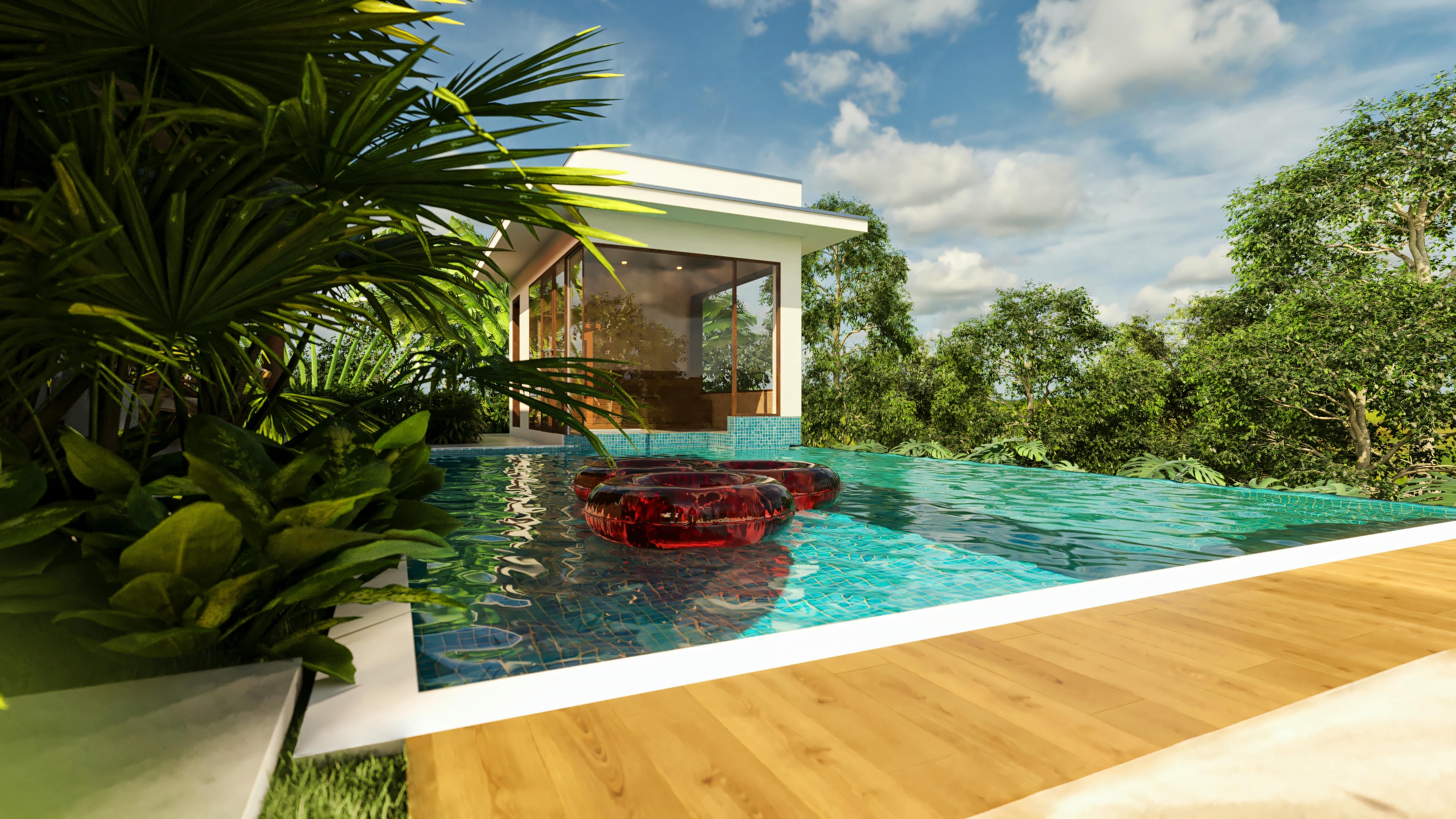 Piscina de casa de lujo con borde de madera en primer plano, flotadores en el agua, edícula acristalada al lado y exuberante paisajismo tropical alrededor, bajo un cielo azul.