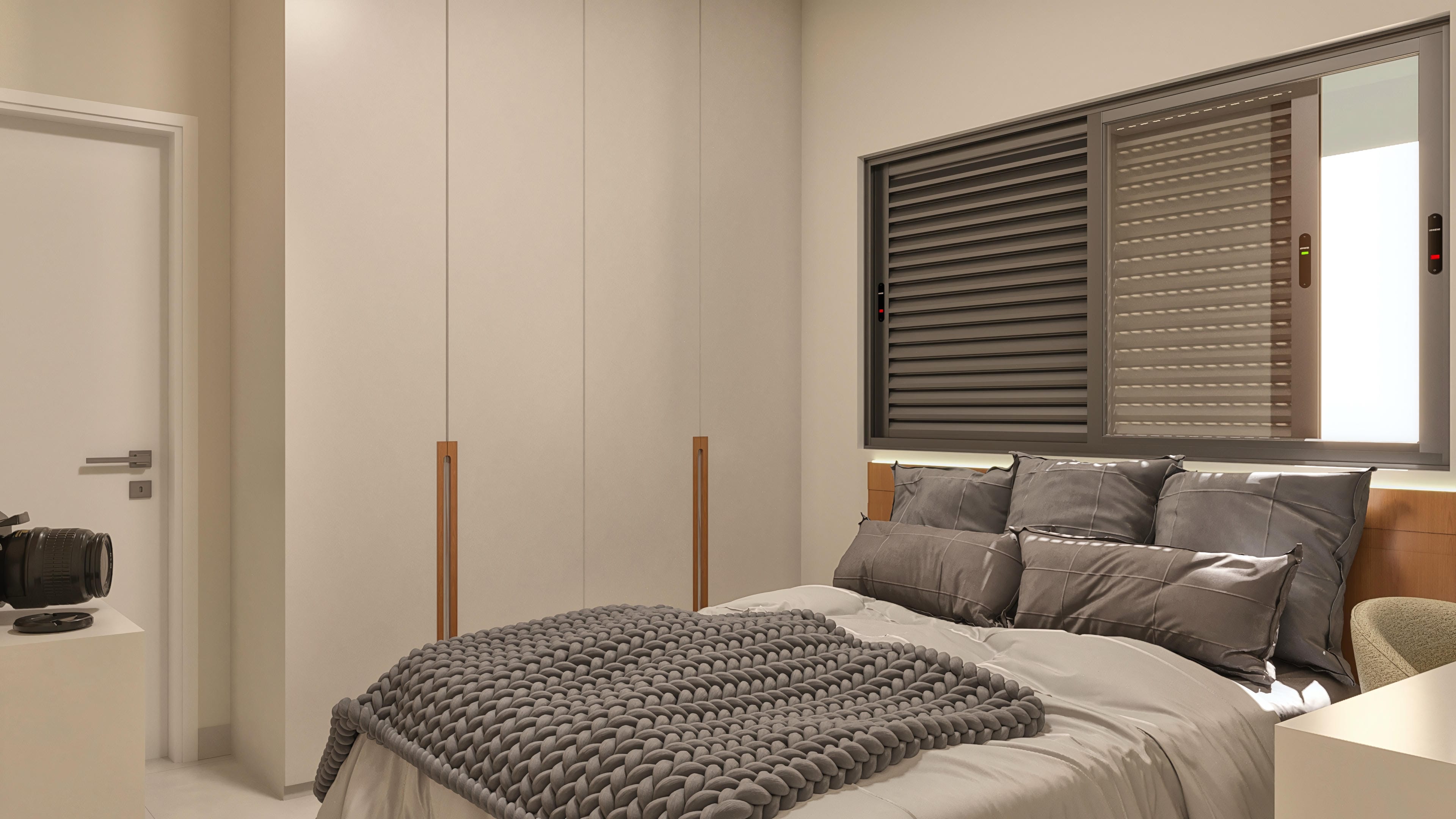 Bedroom with a double bed, gray pillows, thick knitted blanket, built-in custom closets, and a window with blinds.