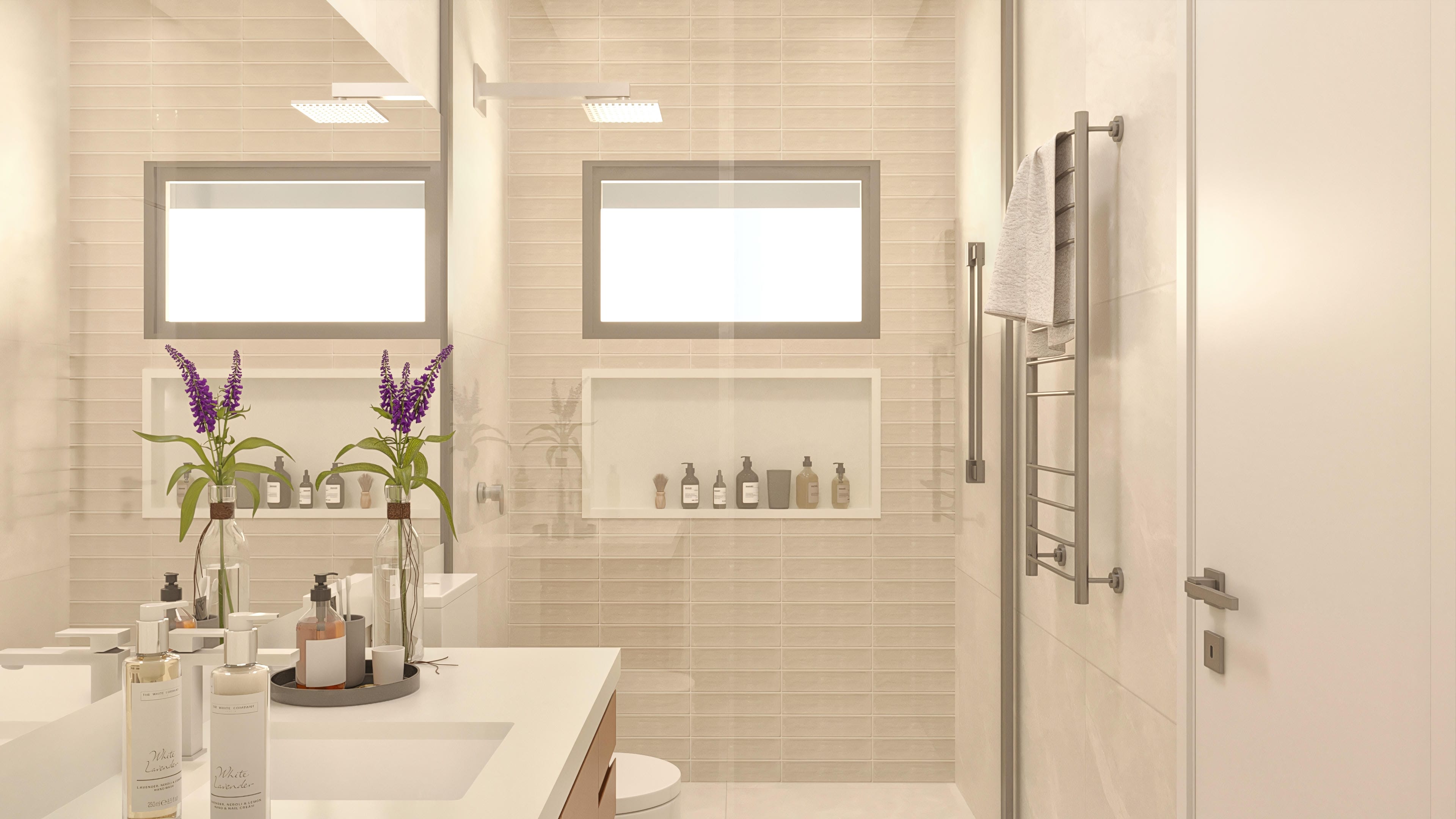 Interior de un baño sofisticado, con revestimiento en tonos beige y detalles en madera. Incluye encimera con lavabos, amplios espejos y hornacinas decorativas.
