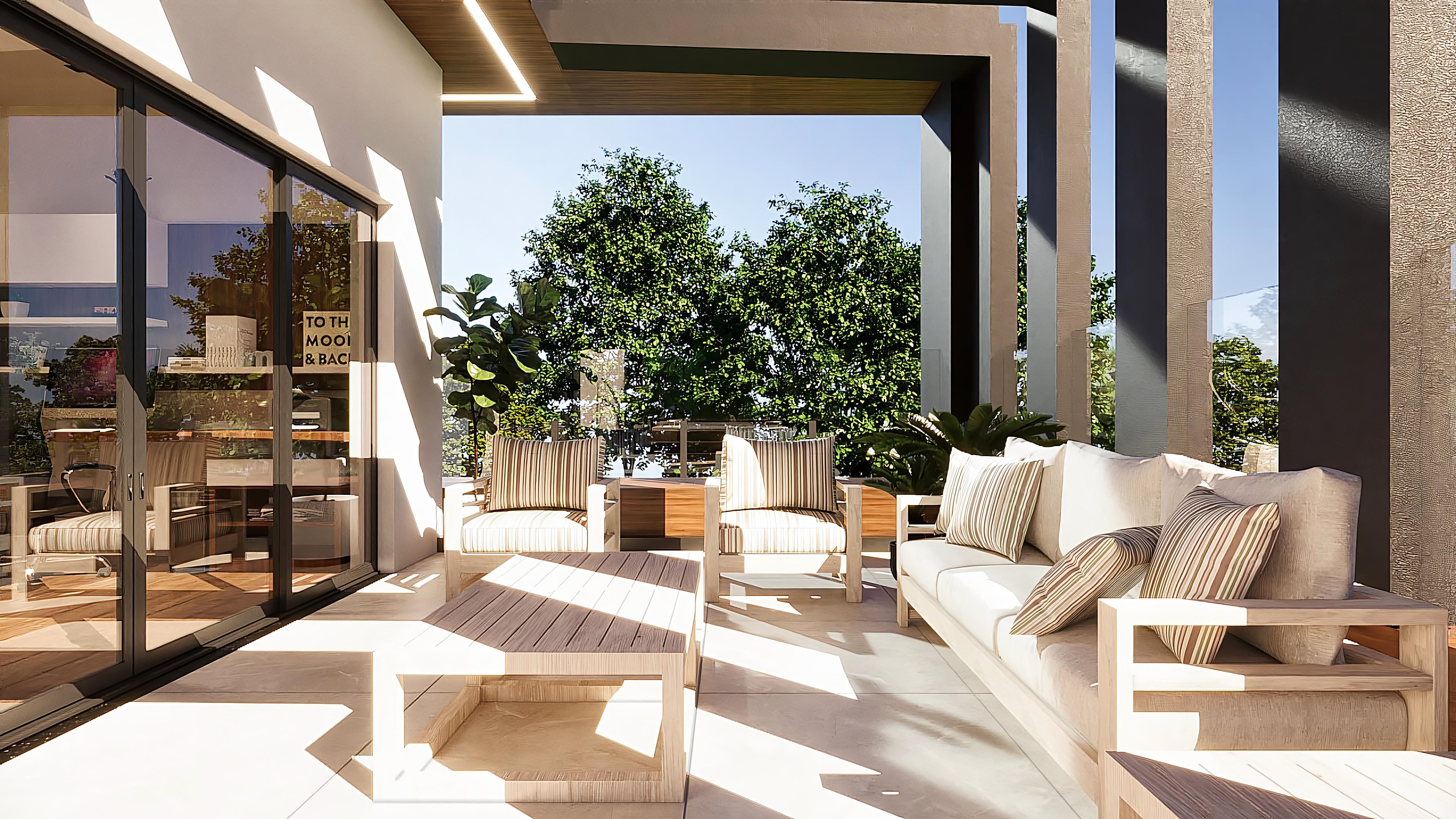 Vista exterior de área gourmet con muebles de madera clara, almohadas a rayas y pilares texturizados en un proyecto neoclásico de alto estándar.