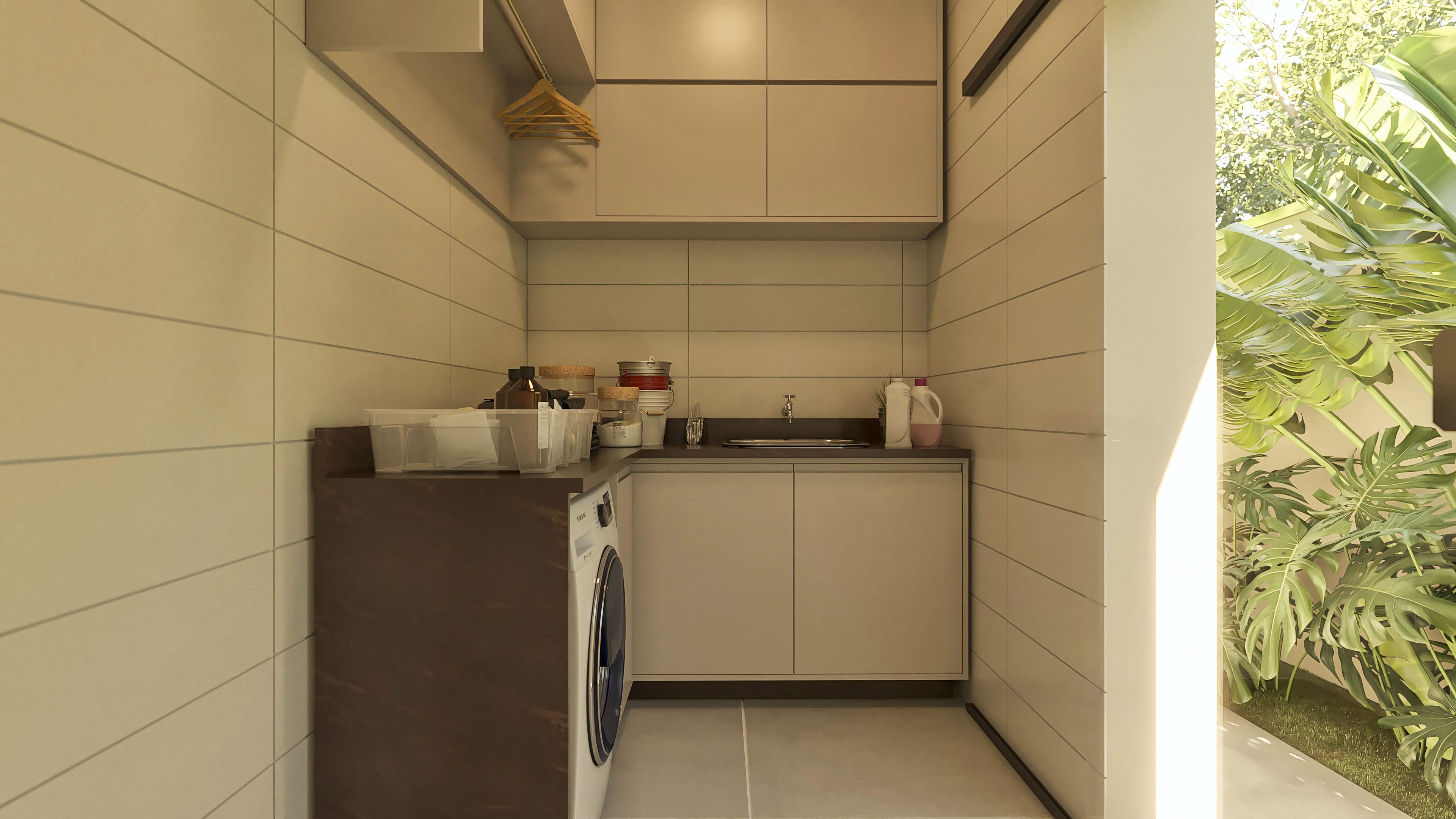 Detalhe de lavanderia com armários planejados, bancada, tanque e máquina de lavar, com vista para área externa com plantas exuberantes e piscina.