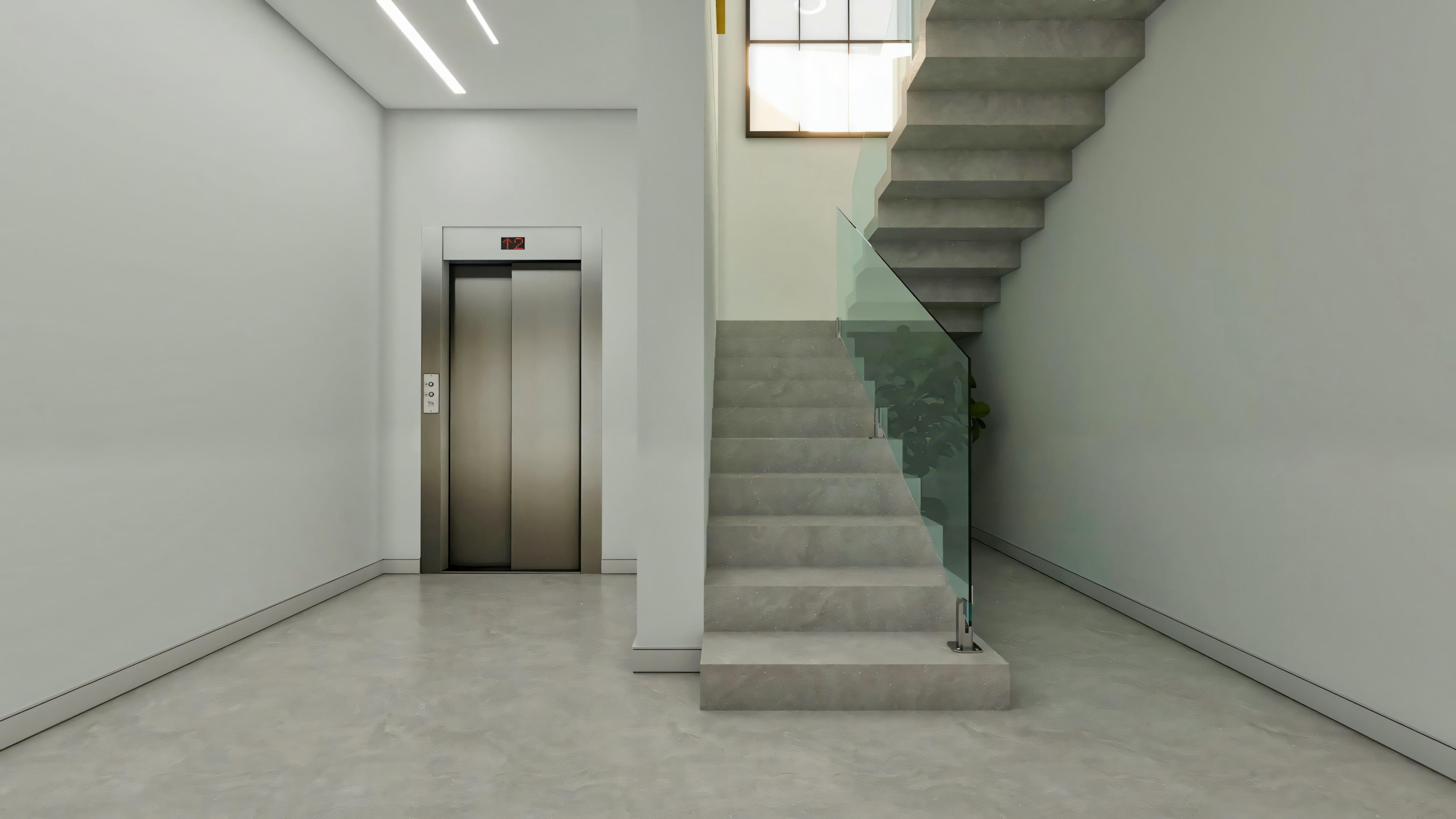 Internal circulation hall in a luxury residential project, with an exposed concrete or cement-finish staircase, glass railing, and private elevator with brushed steel doors.