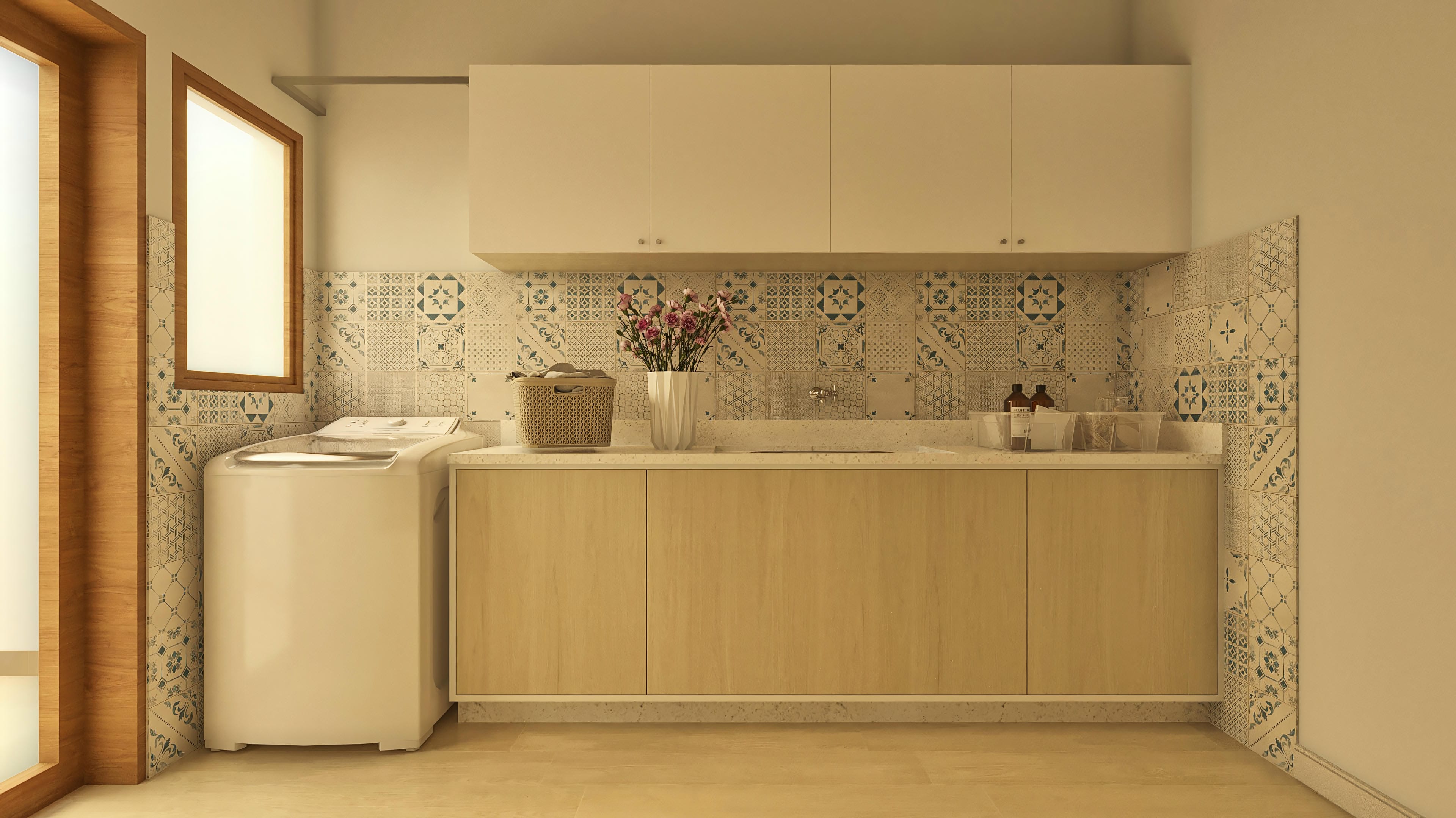 Detail of a laundry room with decorative tiles in shades of blue and beige, marble countertop, light wood cabinets, and washing machine.
