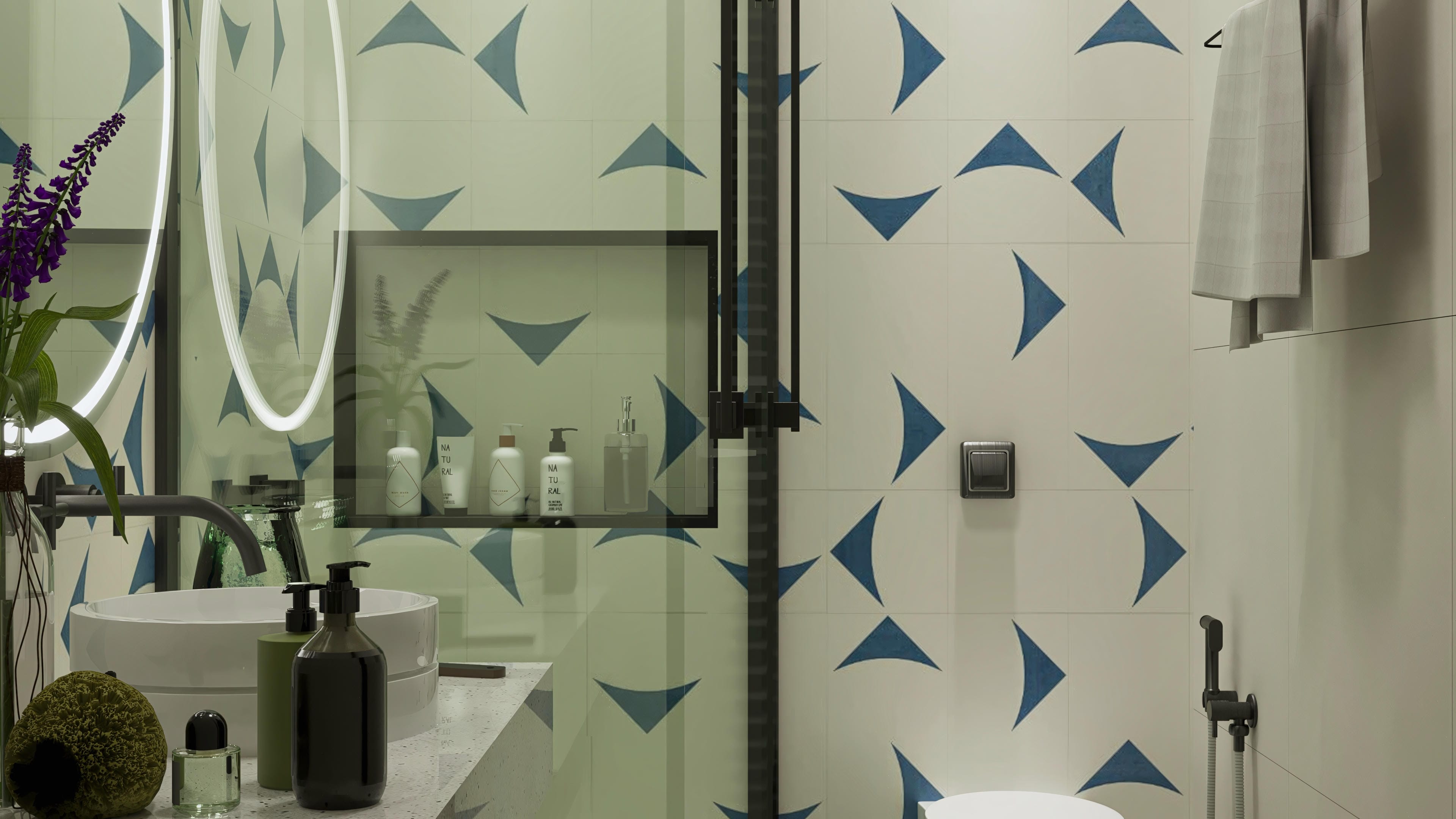 Close-up of a modern bathroom, highlighting the cladding with a blue geometric pattern on a light background, terrazzo countertop, white sink, and black accessories.