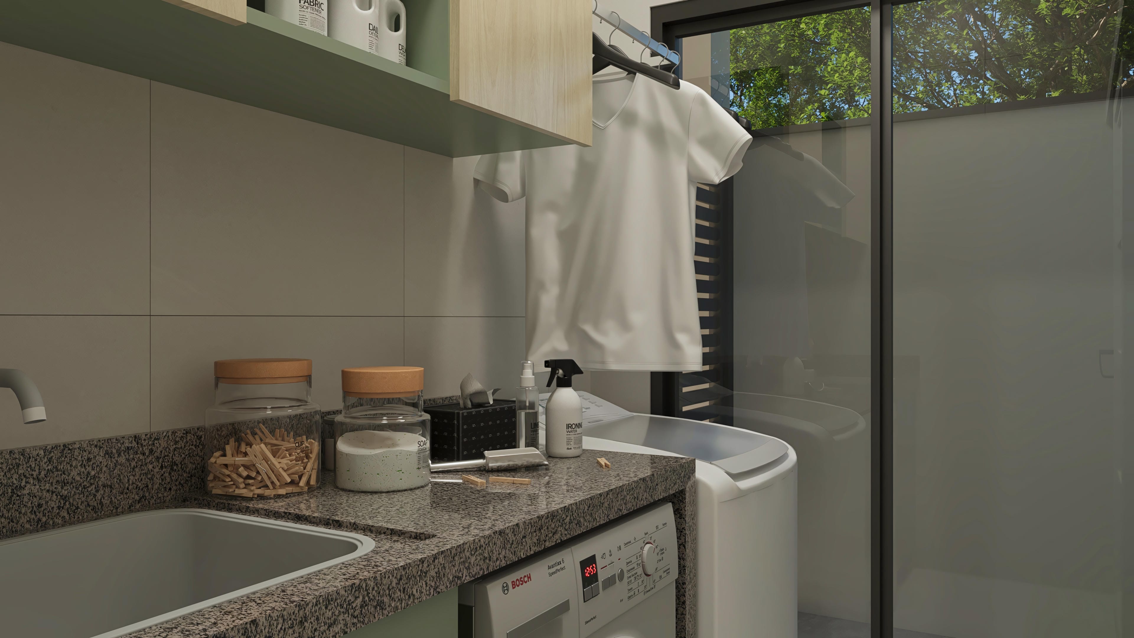 Modern laundry room with textured granite countertop, stainless steel sink, suspended cabinets in neutral tones, and indirect lighting. Large glass window overlooking the greenery.