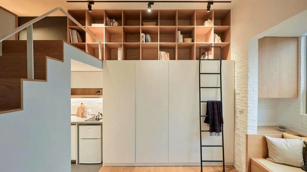 Estantes y nichos empotrados en pared, aprovechando el espacio vertical para almacenamiento en ambiente pequeño.