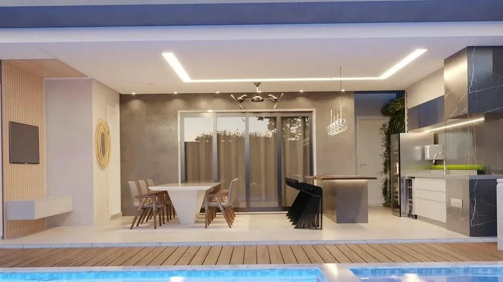 Área gourmet amplia y moderna, con barbacoa y mesa de comedor, ideal para grandes reuniones.