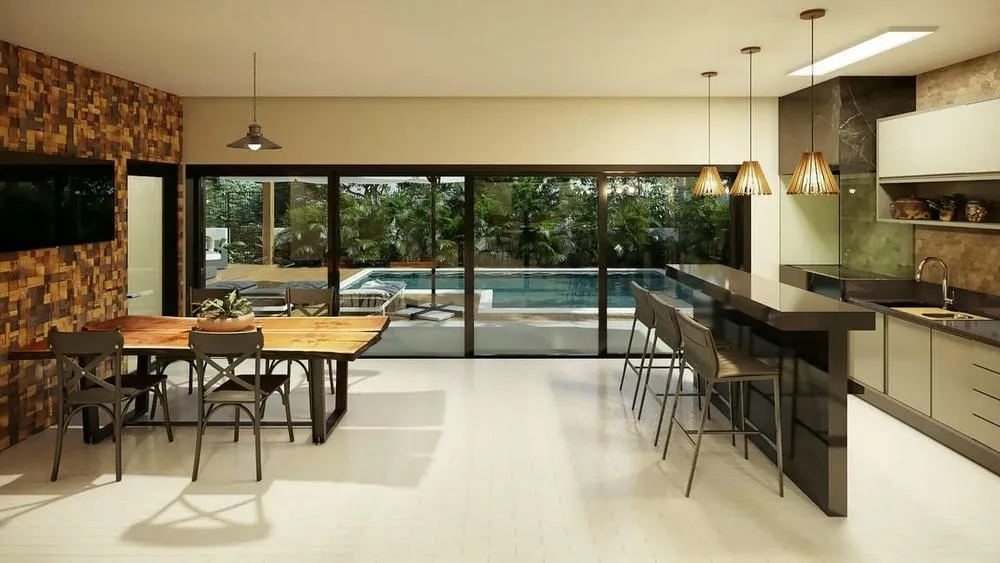 Área gourmet interior del Proyecto Toronto, con encimera central, mesa de madera rústica y puertas de vidrio que integran con el área exterior y la piscina.