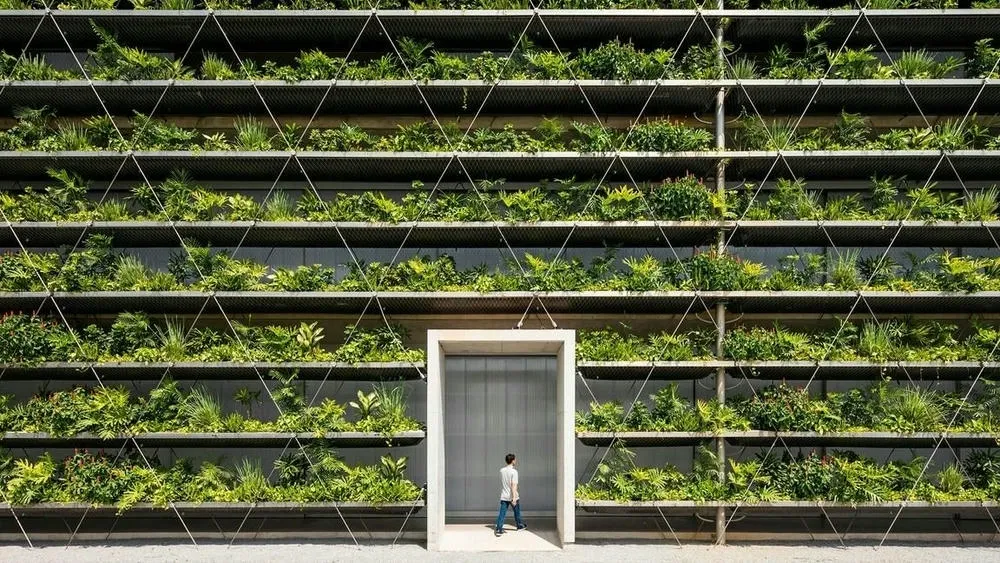 Edificio con diseño verde, paneles solares y techo verde, ilustrando la arquitectura sostenible.