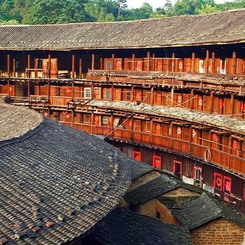 Construcciones Tulou en la provincia de Fujian, China, con tejados oscuros y estructuras circulares de madera.