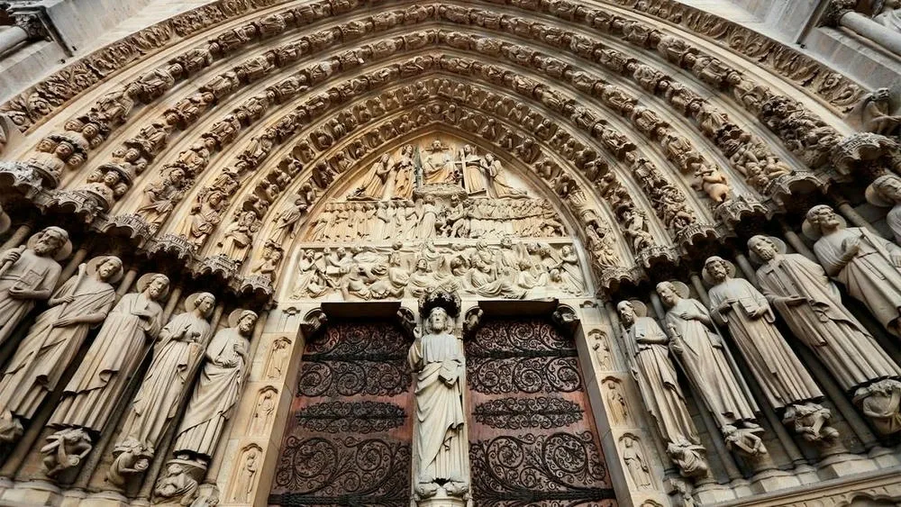 Detalhe de um portal gótico ricamente esculpido com figuras religiosas na Catedral de Notre-Dame.