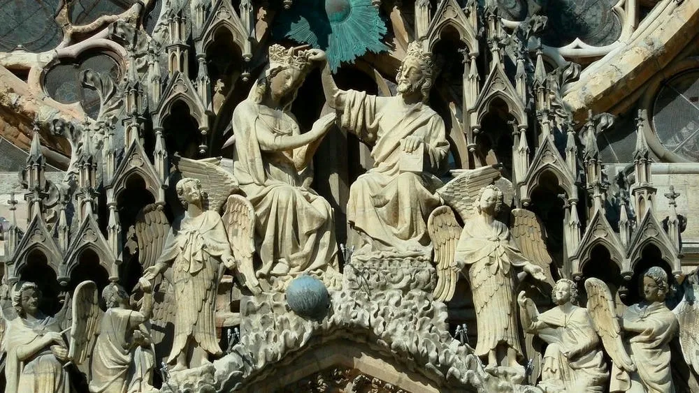 Detalhes de esculturas e ornamentos em pedra na fachada de uma catedral gótica.