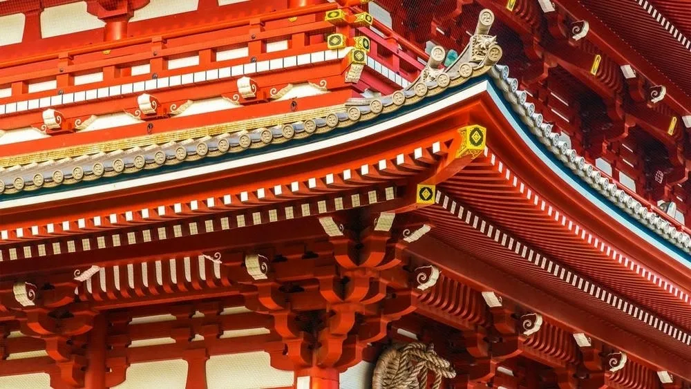 Arquitetura tradicional chinesa com detalhes em vermelho, incluindo um portão e lanternas, simbolizando boa sorte e prosperidade.