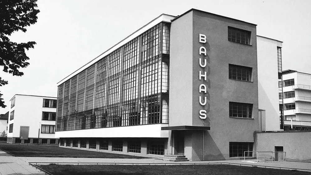 Facade of the Bauhaus building, in black and white, with its large ribbon windows and the word 'BAUHAUS' highlighted.