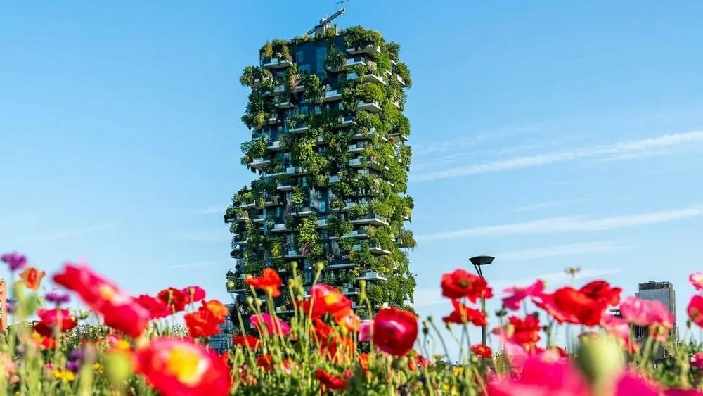 Two towers of Bosco Verticale in Italy, with trees and dense vegetation on their facades.