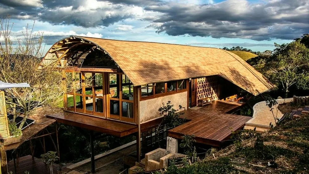 Fachada de la Casa das Birutas en Piracaia, São Paulo, con elementos naturales y diseño sostenible.