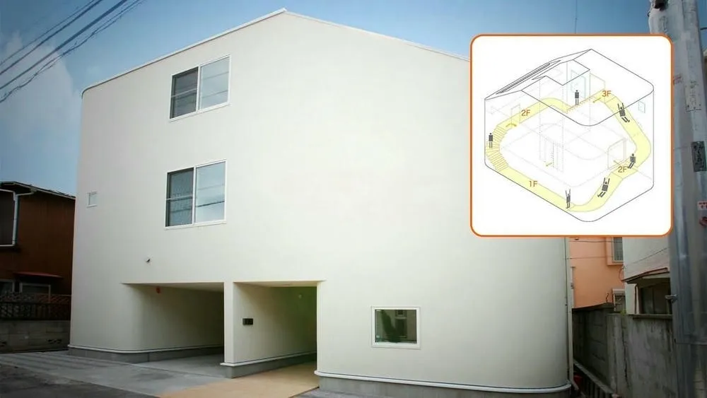 Fachada externa de la Slide House en Japón, con diseño moderno y un tobogán interno visible.