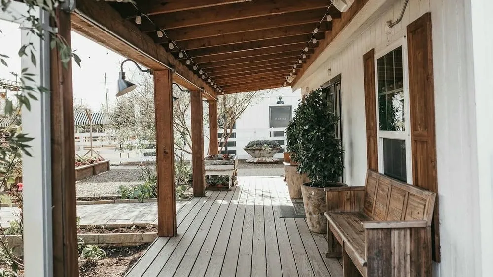 Interiors of a house with rustic elements, large openings, and landscaping, highlighting the connection with nature.