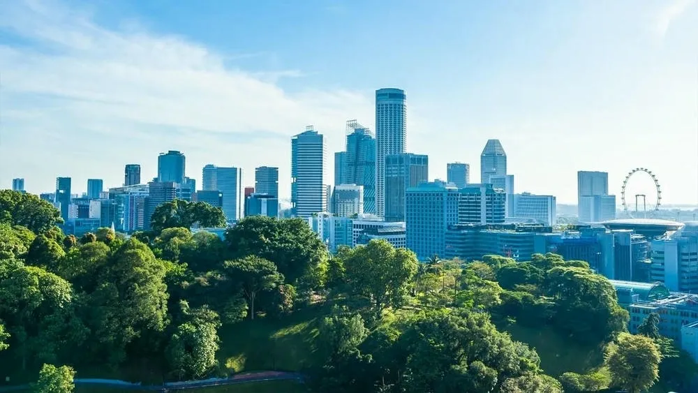 Vista panorámica de una ciudad moderna con rascacielos y abundancia de áreas verdes, sugiriendo el contraste entre la apariencia y la realidad de la sostenibilidad arquitectónica.