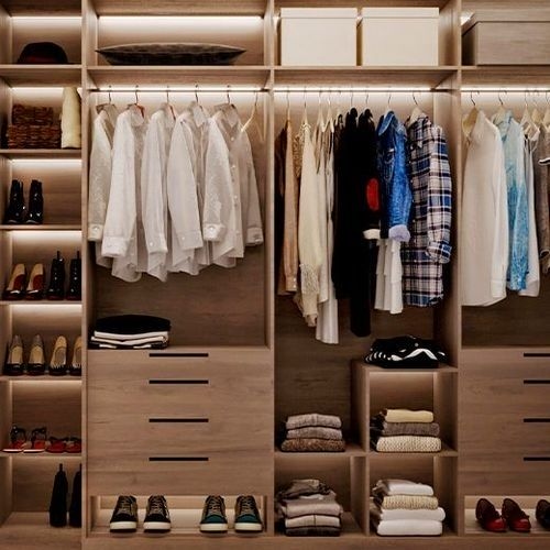 A spacious and organized closet with shelves and hangers, in light tones, ideal for suites.