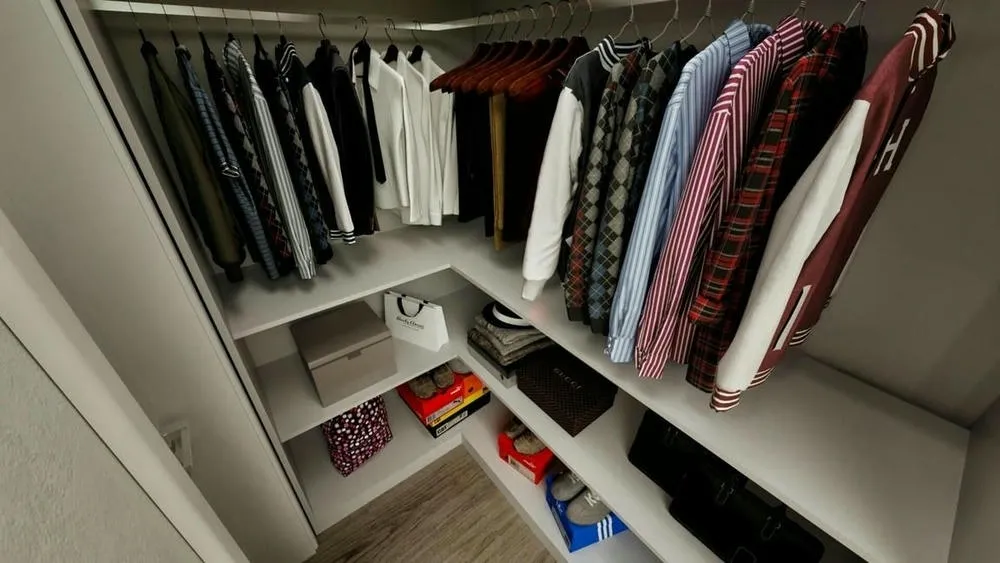 Closet pequeno com roupas penduradas e prateleiras para sapatos e caixas, maximizando o uso do canto.