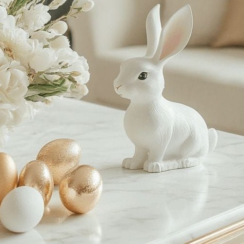 Um elegante coelhinho branco de Páscoa em mármore, ladeado por ovos dourados e um arranjo floral branco, em uma composição moderna e sofisticada.