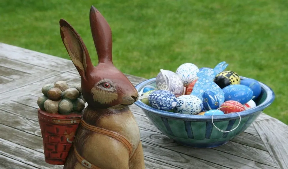 Cesta con huevos decorados y flores, elementos naturales para la Pascua.