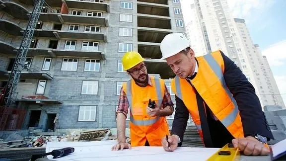 Arquitectos e ingenieros trabajando juntos en un proyecto de construcción.