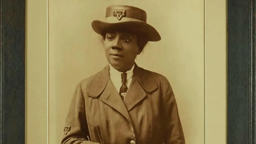 Old sepia portrait of Elizabeth Carter Brooks, framed, with the YWCA logo on her hat.
