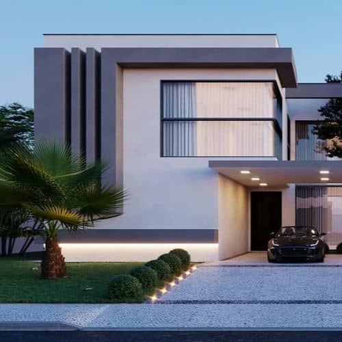 Fachada de casa moderna com detalhes em cinza e branco, iluminação paisagística e jardim bem cuidado, demonstrando elementos de um projeto de arquitetura de alto padrão.