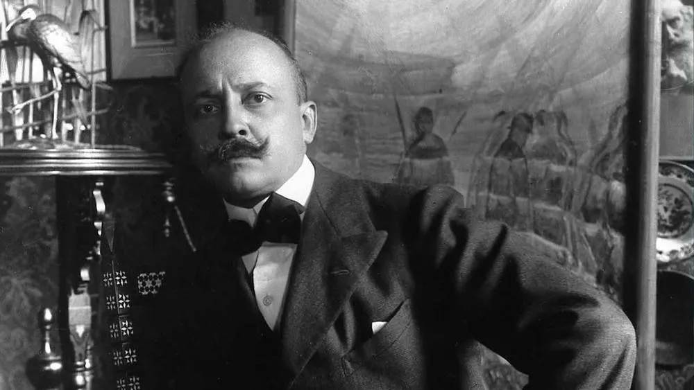 Retrato en blanco y negro de Filippo Tommaso Marinetti, fundador del movimiento futurista, con bigote y vistiendo un traje.