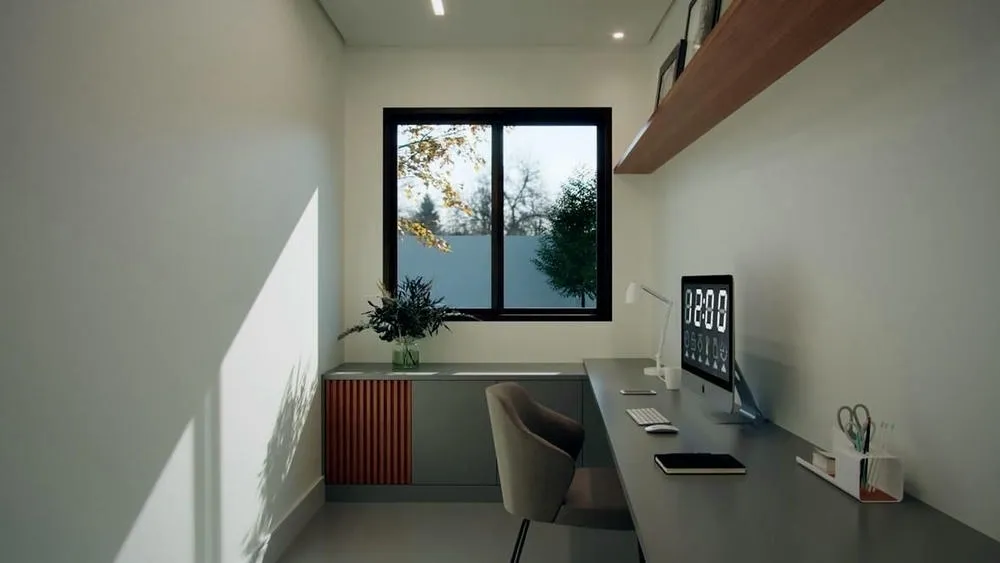 Home office minimalista com janela que proporciona boa iluminação natural, mesa de trabalho e uma planta decorativa.