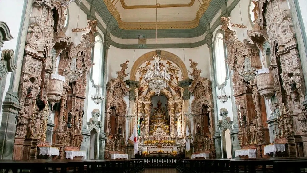 Interior de uma igreja barroca em Salvador, Bahia, com altares ricamente decorados e talhas douradas.