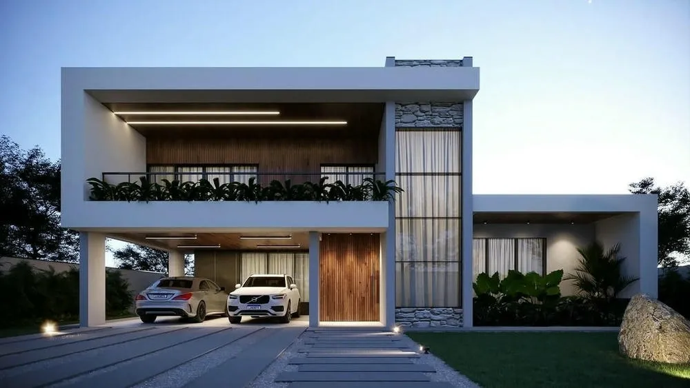 Fachada de casa moderna con iluminación externa destacando la arquitectura y el paisajismo nocturno.