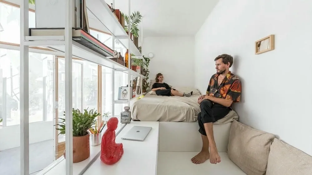 Ambiente con grandes ventanas y estantes bien iluminados, destacando la importancia de la luz natural en espacios pequeños.