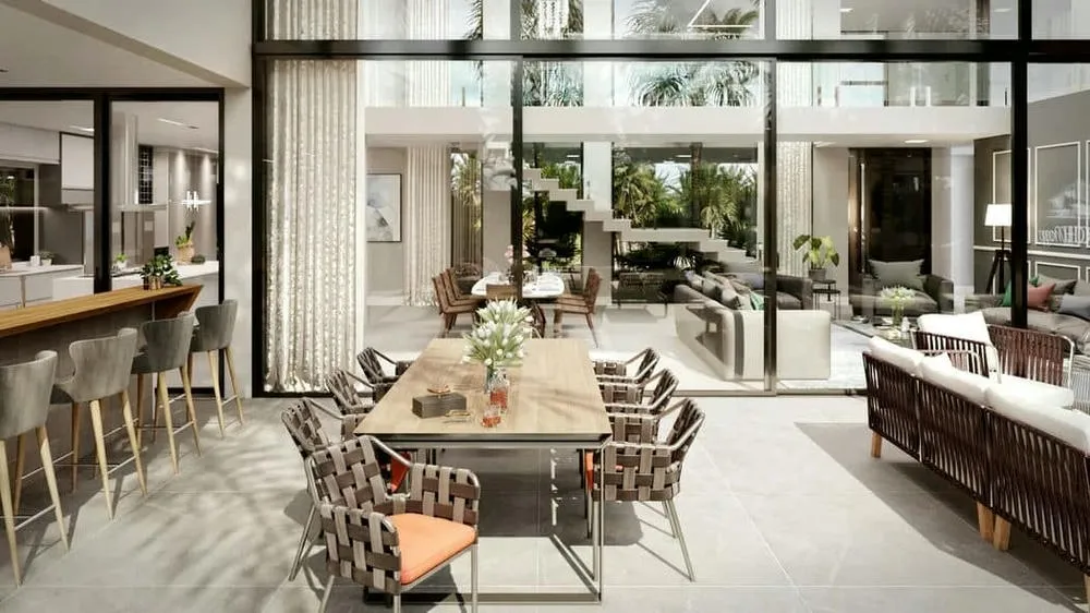 Integrated social area of a luxury two-story house, with connected dining and living rooms, large windows, and view of the pool.