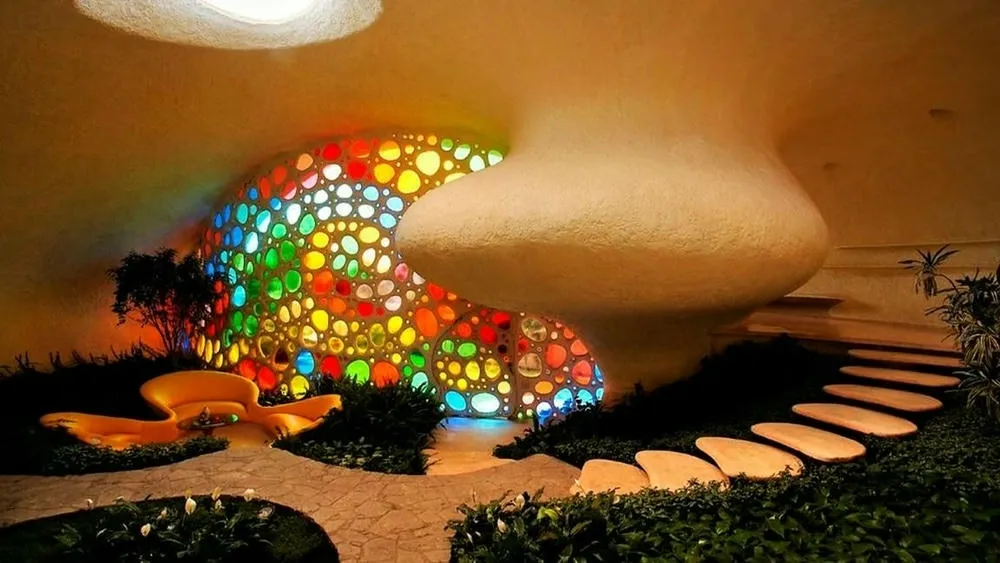Interior da Nautilus House, com jardim interno e formas curvilíneas que se integram à natureza.