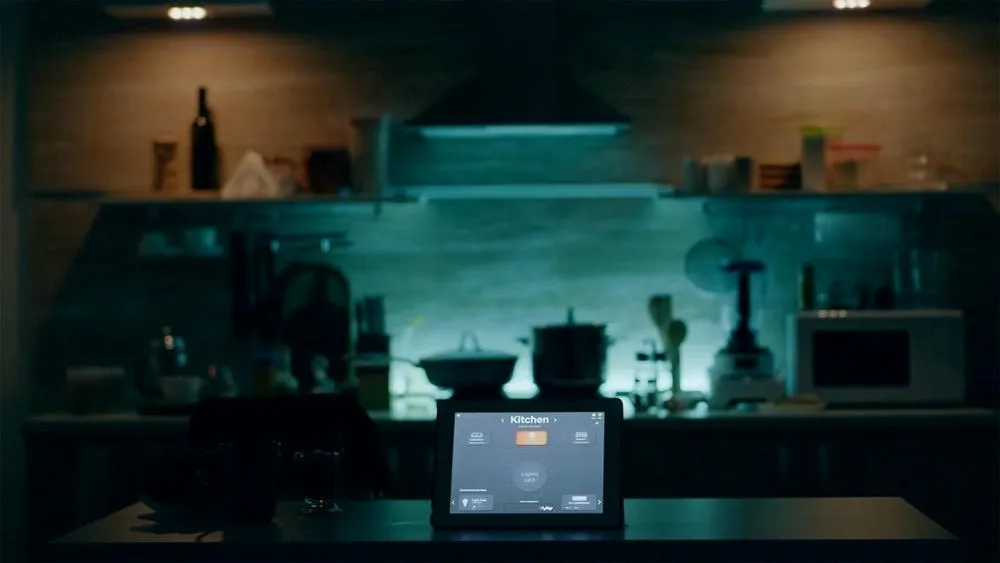 Kitchen with smart lighting and a tablet in the center of the counter controlling lights and other devices, showing how home automation works in practice.