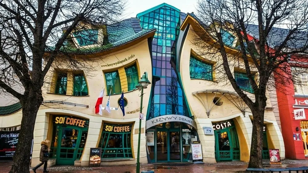 Fachada externa de la Krzywy Domek en Polonia, conocida como 'Casa Torcida', con curvas inusuales.