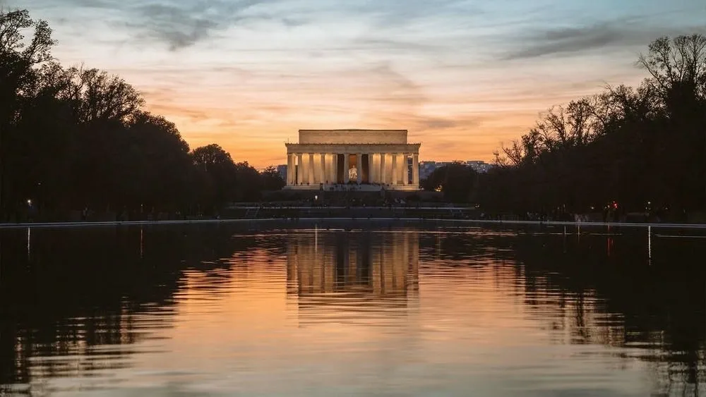 El Monumento a Lincoln en Washington D.C., con su estructura clásica reflejada en el gran espejo de agua frente a él.