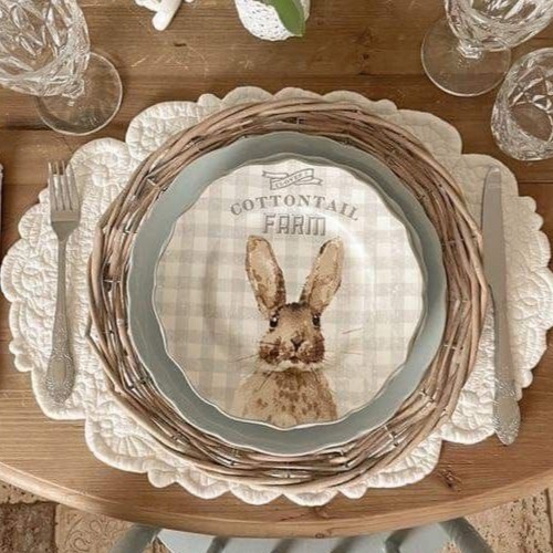 Acessório de mesa elegante para Páscoa com toalha de crochê branca, porta-prato de vime, prato com estampa xadrez clara e desenho de coelhinho da fazenda Cottontail Farm.