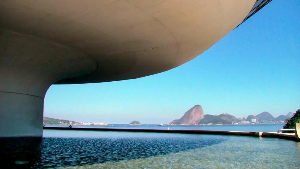 El Museo de Arte Contemporáneo de Niterói (MAC), con su formato de platillo volador y rampa, rodeado por un espejo de agua.
