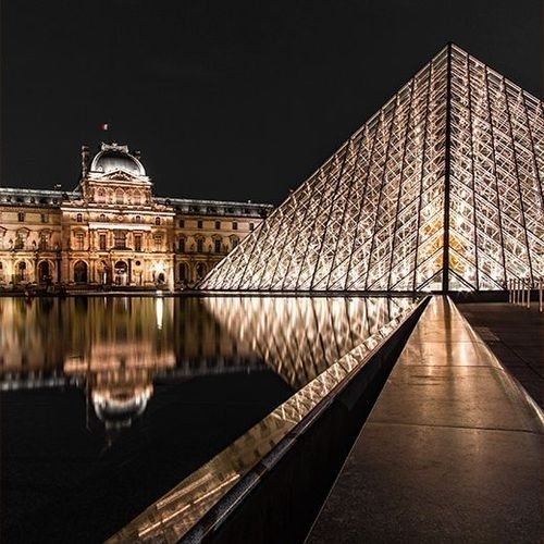 Vista frontal del Museo del Mañana, en Río de Janeiro, con su diseño futurista reflejado en un gran espejo de agua al frente.