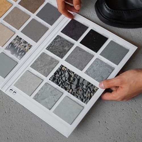 Palette of neutral color samples for architecture and interior design, with shades of gray, beige, and black, including a stone sample that harmonizes with the colors.