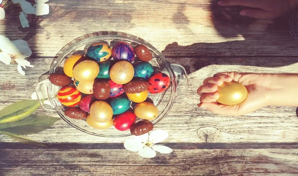 Niño buscando huevos de Pascua en ambiente decorado.
