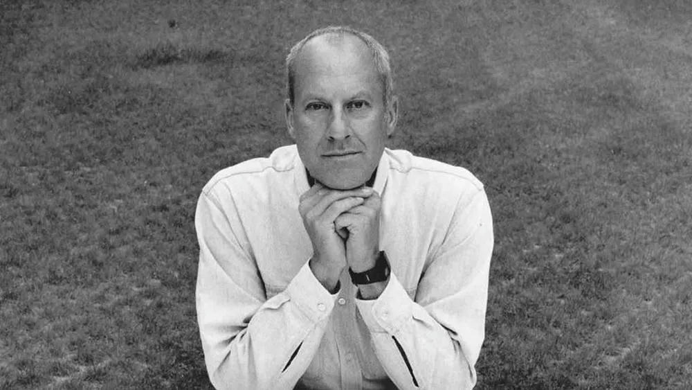 Retrato em preto e branco de Norman Foster, arquiteto famoso, com as mãos sob o queixo.