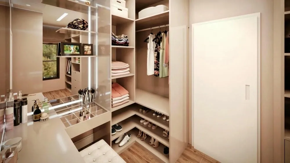 Open closet with shelves, hangers and a mirrored vanity, displaying organized clothes and accessories.