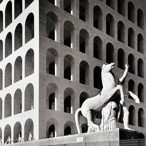 Facade of the Palazzo della Civiltà Italiana, example of futuristic architecture with repeated arches and horse statue.